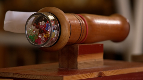 A handmade kaleidoscope - A long wooden cylindrical tube.
