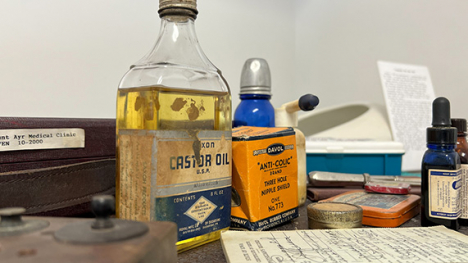 Glass medicine bottles and papers sitting on a desk.