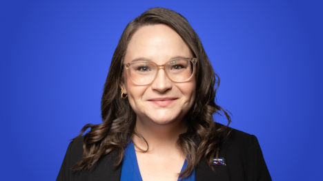 Caryline Clark, a woman with brown hair and glasses smiing at the camera. 