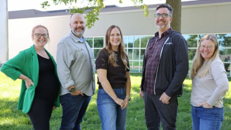 Five people standing in front of the Iowa PBS building. 