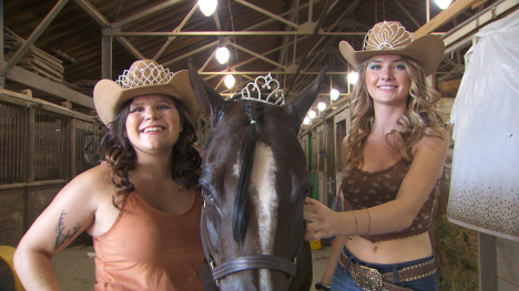 Two cowgirl queen contestants with a horse – all wearing tiaras. 