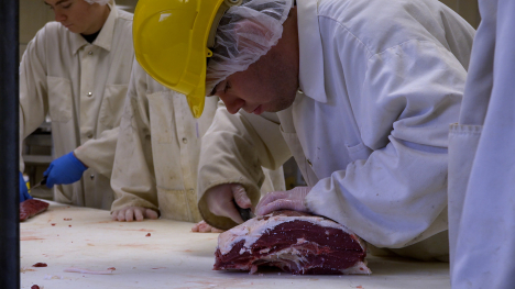 student cutting meat