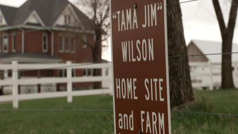 A sign in front of a farmstead reads, "TAMA JIM" WILSON HOME SITE and FARM"