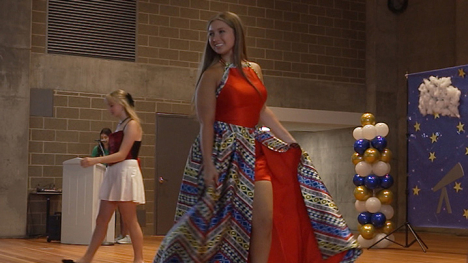 4-H competitor showcases her red outfit with a blue, red and gold patterned floor length skirt