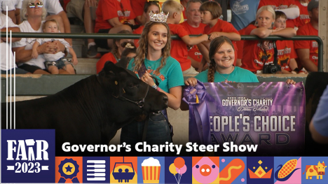 Governor’s Charity Steer Show - two people standing next to a steer