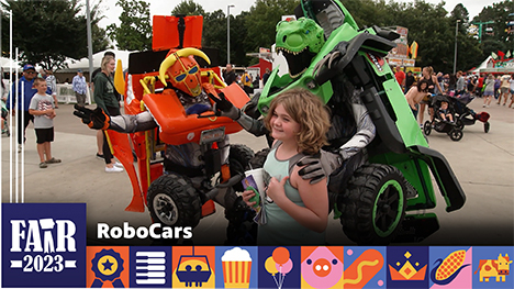 RoboCars - Two RoboCar characters pose for a photo with a girl at the Iowa State Fair.