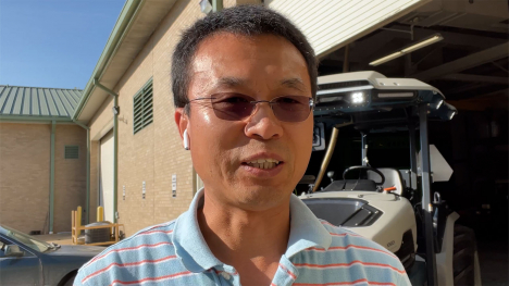 Dr. Jianfeng Zhou in front of electric tractor 