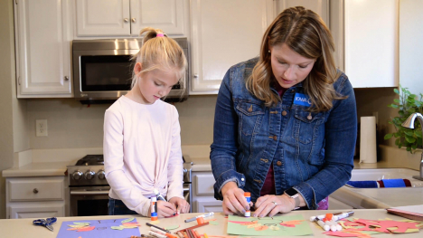 Abby Brown and a friend working on a gratitude turkey craft in the kitchen
