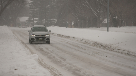 Car driving on a snowy Iowa road.