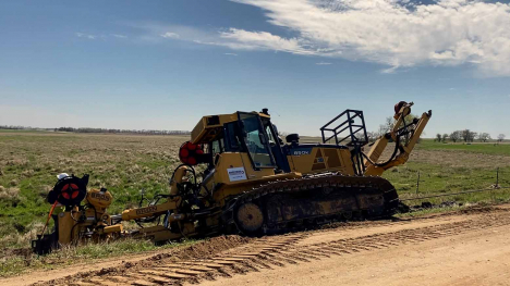 Bulldozer plowing fiber optic cables