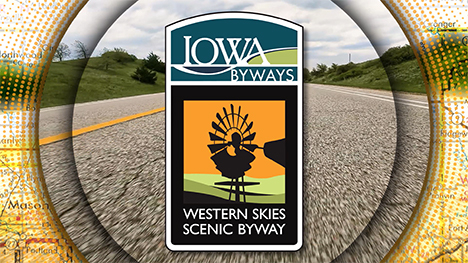 Iowa Byways: Western Skies Scenic Byway sign overlayed on a road background.