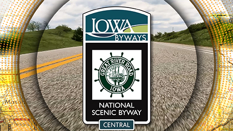 Iowa Byways: Great River Road National Scenic Byway sign overlayed on a road background.