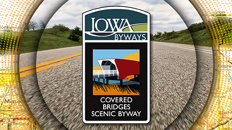 Iowa Byways: Covered Bridges Scenic Byway sign overlayed on a road background.