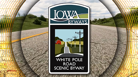 Iowa Byways: White Pole Road Scenic Byway sign overlayed on a road background.
