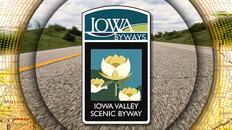 Iowa Byways: Iowa Valley Scenic Byway sign overlayed on a road background.