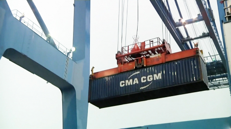 A 40- foot shipping container being unloaded from cargo ship.  The shipping container is the base unit of international trade, and an image of one container is a symbol for all of global trade.
