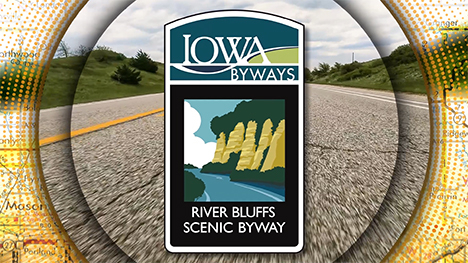 Iowa Byways: River Bluffs Scenic Byway sign overlayed on a road background.