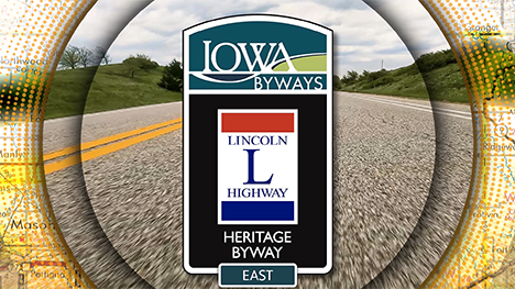 Iowa Byways: Lincoln Highway Heritage Byway East sign overlayed on a road background.