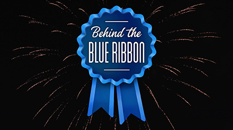 Behind the Blue Ribbon logo of a blue ribbon against a fireworks explosion in the night sky.