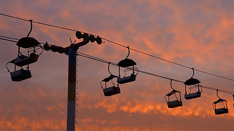 The Iowa State Fair SkyGlider silhouetted against the morning lit clouds.