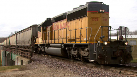 A train engine and train cars traverse a bridge.