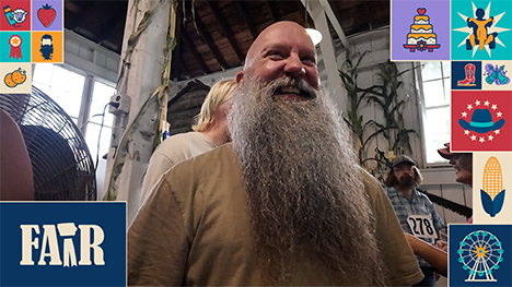 A contestant at the beard growing contest smiles and shows off his beard.