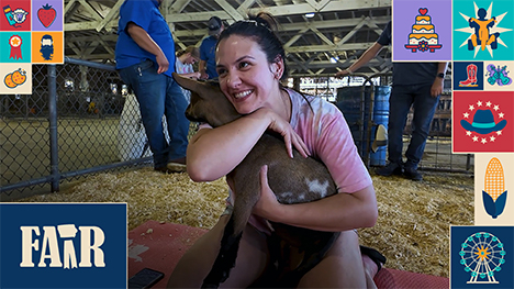 A woman hugs a goat during a session of Goat Yoga at the Iowa State Fair.