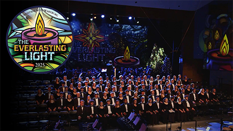 The Christmas With Wartburg: The Everlasting Light 2025 logo in the upper left corner of a photo of the choir onstage at Wartburg college.