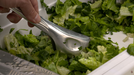 tongs picking up chopped salad