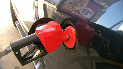 Gas pump handle in fill port of pickup truck.