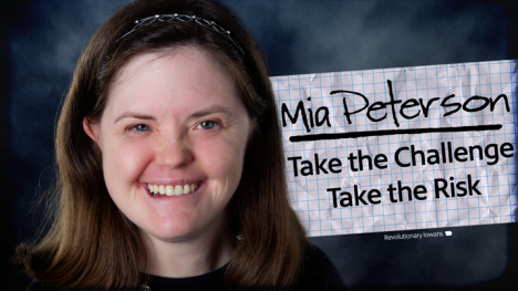 A woman with shoulder length brown hair and blue eyes smiles in a professional portrait.