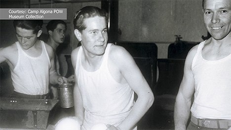 Four men in white tank tops working at Camp Algona.