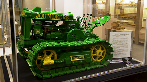 A scale "toy" version of a green and yellow John Deere implement.