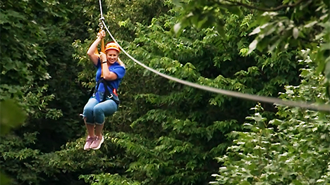 Host, Brooke Kohlsdorf ziplining through the trees.