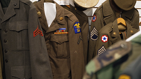 Military uniforms on hangers.