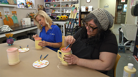 Host, Brooke Kohlsdorf paints a mug with another woman at The Le Mars Art Center.