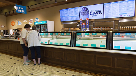 Two women look into the glass case coolers to make ice cream selections at the Wells Visitor Center & Ice Cream Parlor.