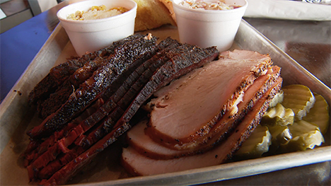 A fresh tray of sliced BBQ brisket, pickles, and more!
