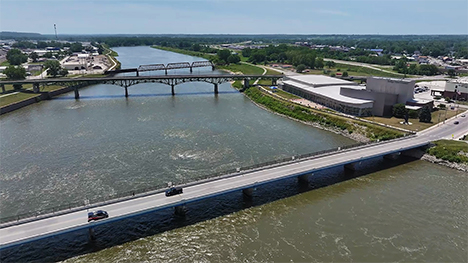An aerial view of a three bridges over a river in a small Iowa town.