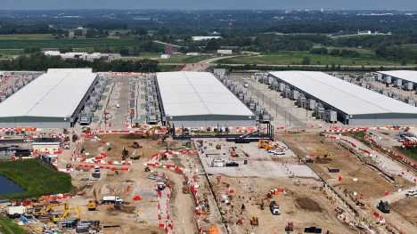 Aerial view of large data center buildings under expansion near Cumming, Iowa.