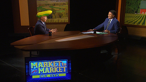 Ted Seifried and Paul Yeager at the Market to Market desk. Ted wears a corn cob hat.